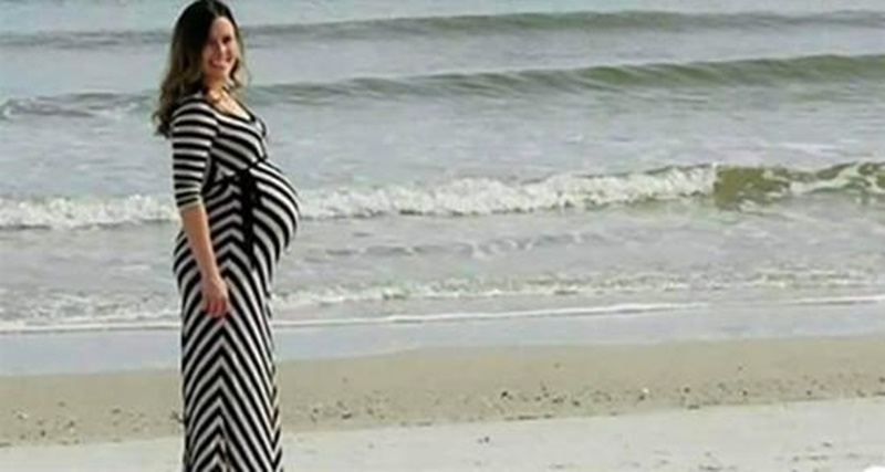 Marido tira uma fotografia da mulher grávida na praia, porém preste bem atenção no que aparece à direita da foto